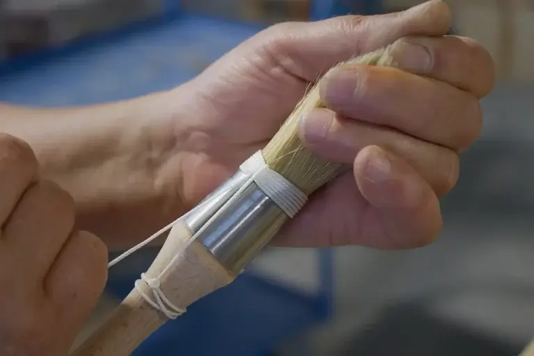 Ligature pinceau peinture Malige – fabrication artisanale française en atelier Ligature pinceau peinture réalisée en atelier chez Malige, savoir-faire artisanal français sur pinceau rechampir professionnel